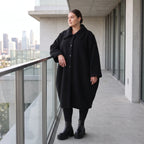 Schwarzer Teddymantel in Ballonform mit Hemdkragen Knopfverschluss und Seitentaschen