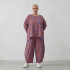 Ballonhose in lilaorange mit Blumenprint weit geschnitten und tiefen aufgesetzten Taschen